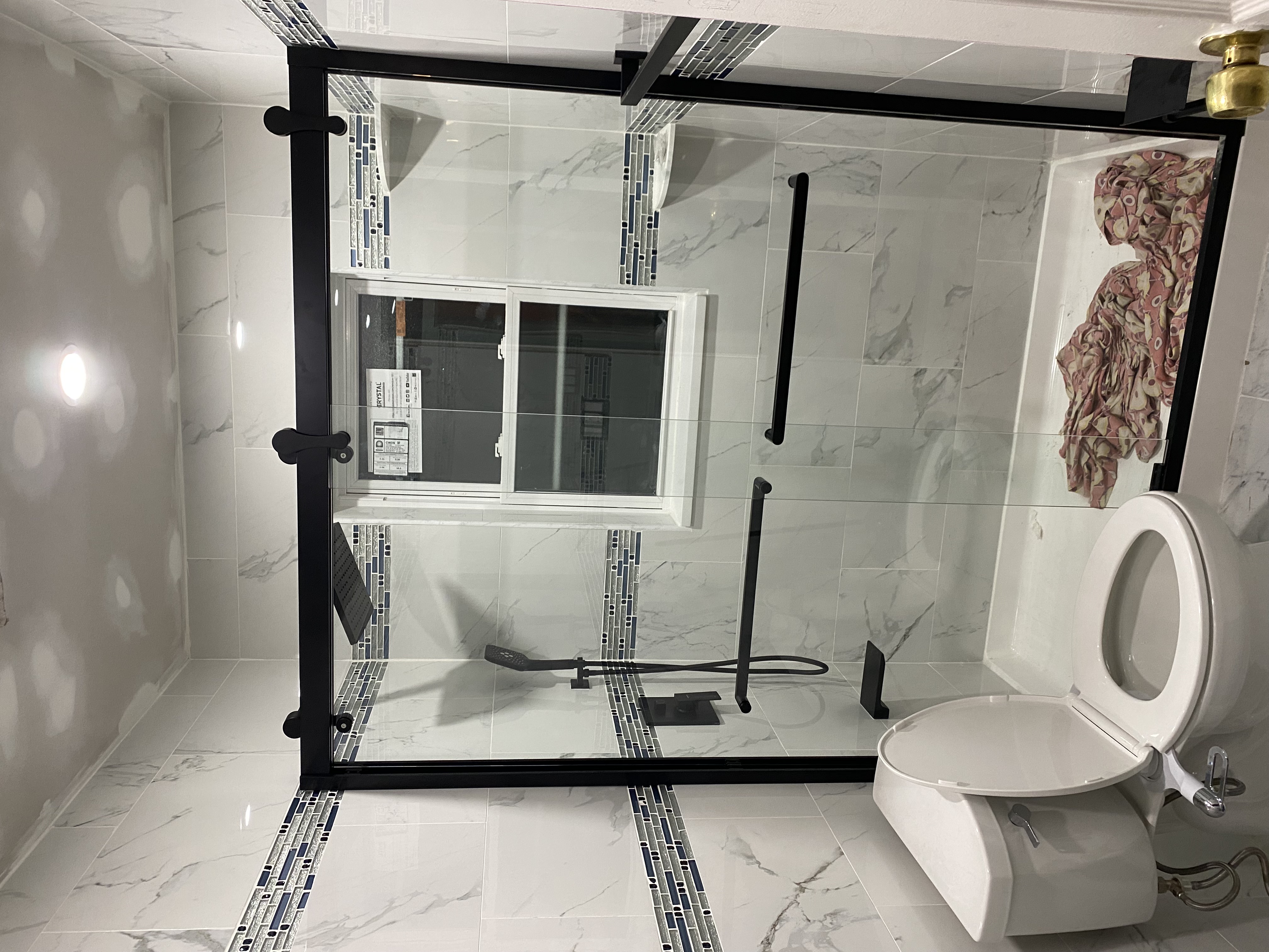 Bathroom remodel with marble tile and glass shower enclosure
