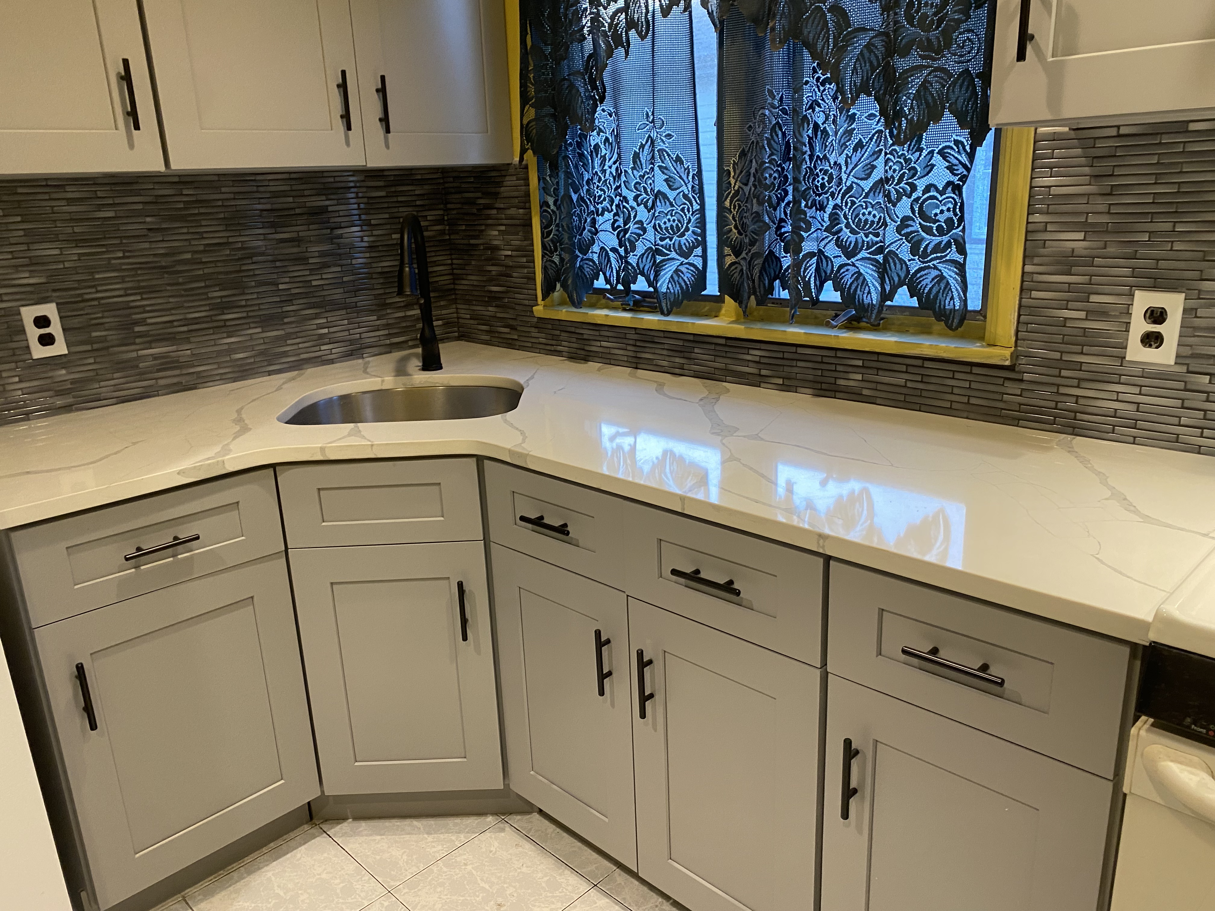 Kitchen remodel with gray shaker cabinets and quartz countertops